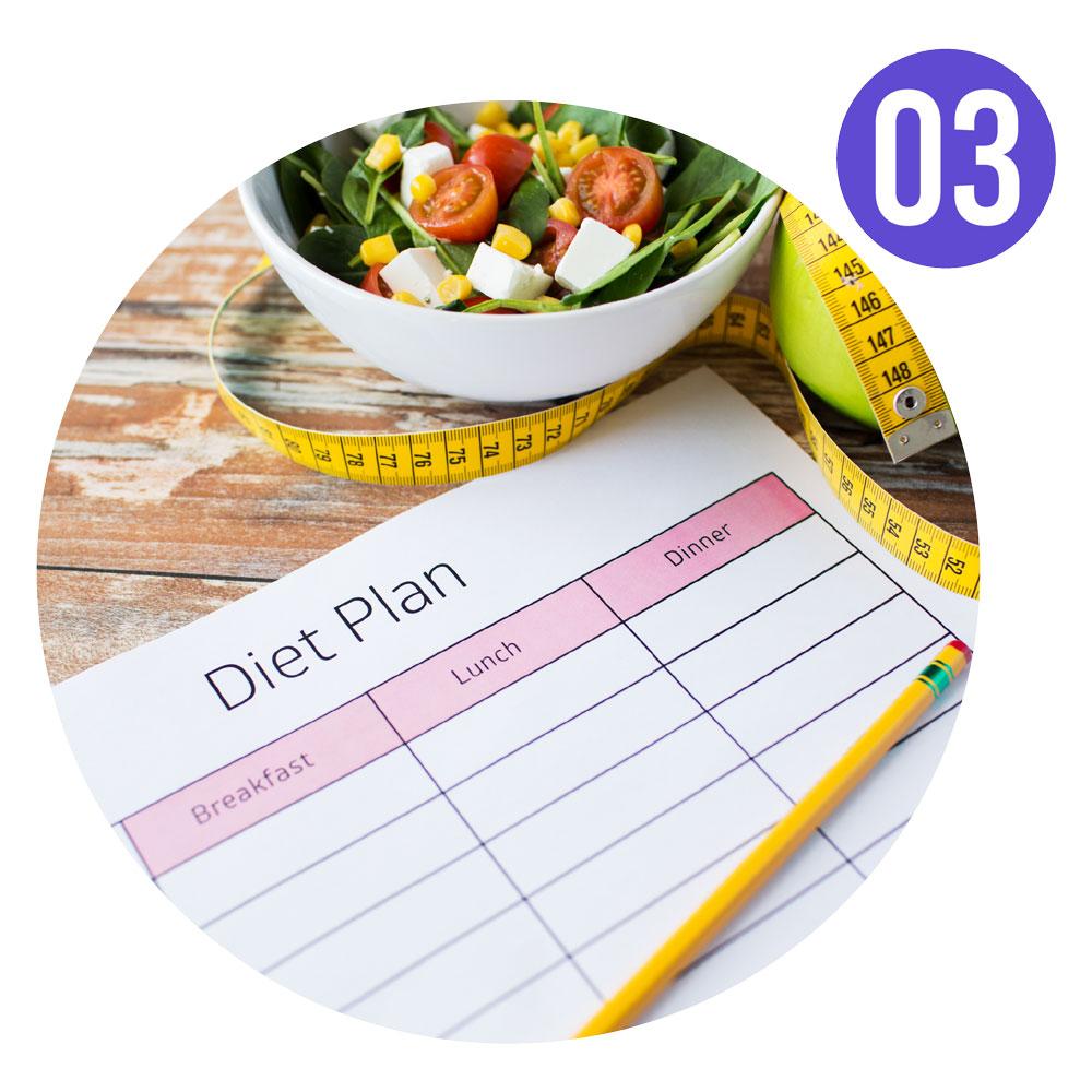 Diet plan on a desk next to a bowl of healthy salad